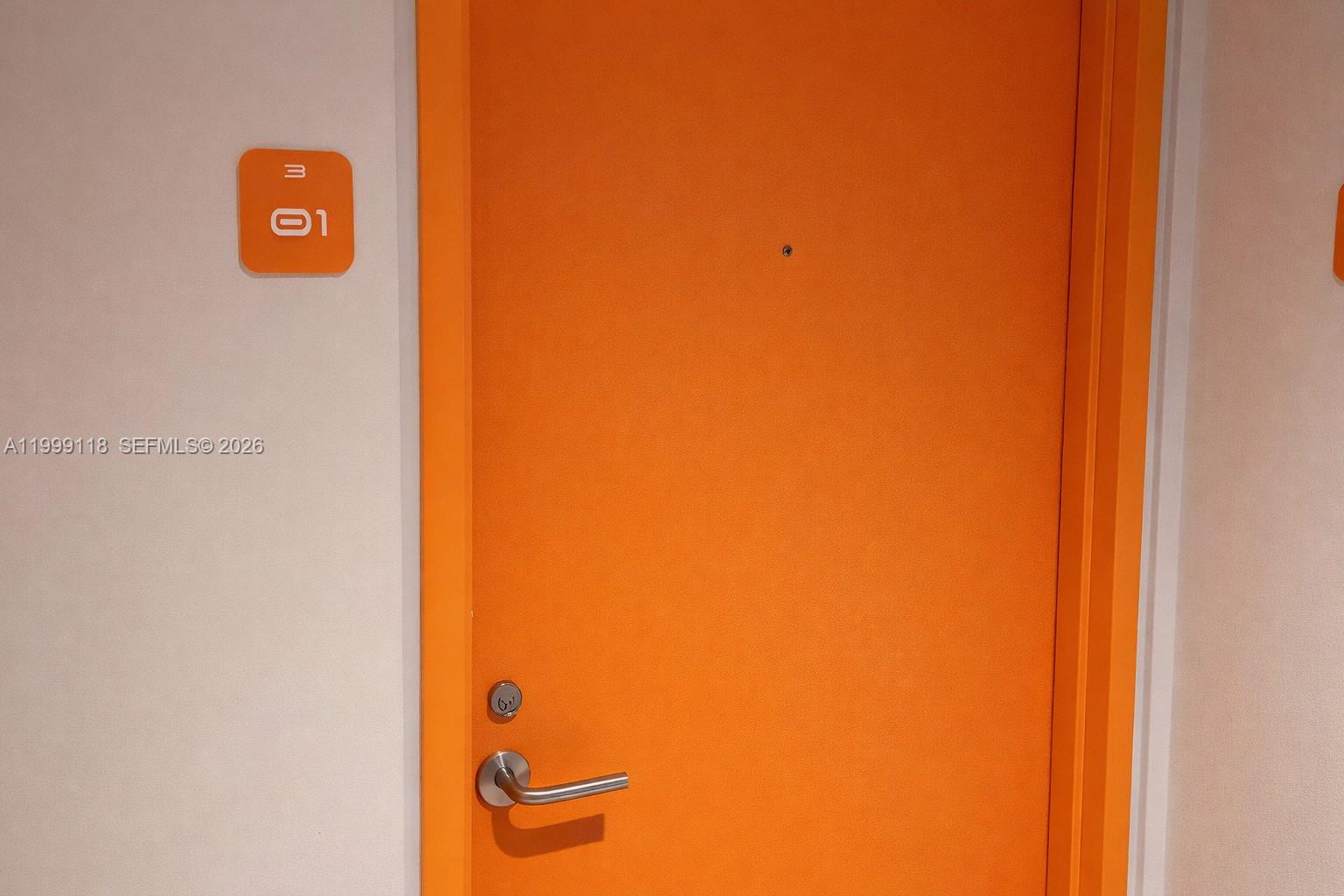 A bright orange door with a silver handle and a room number sign — 31 SE 6th St # 301, Miami FL 33131, MIAMI, FL