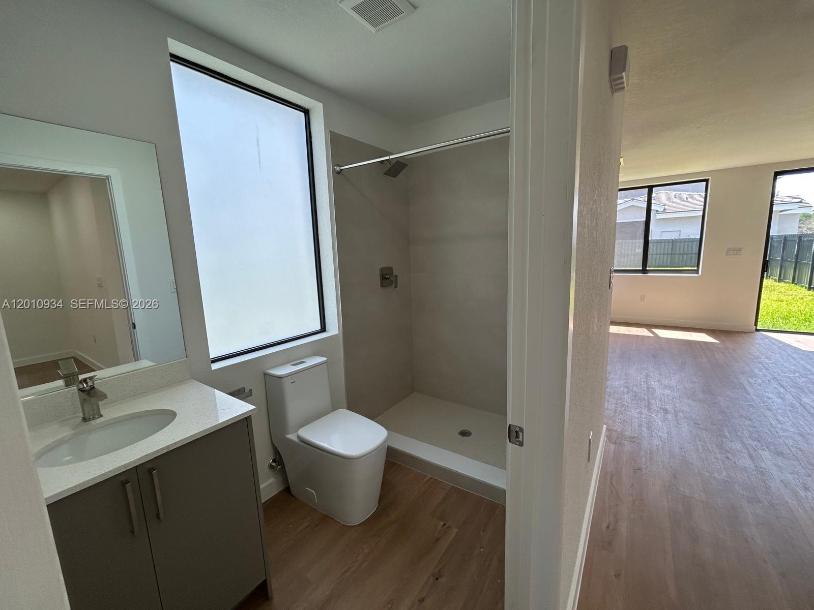 An empty room features white walls, recessed lighting, and light wood-look flooring — 19442 SW 125th AVE # 0, Miami FL 33177, MIAMI, FL
