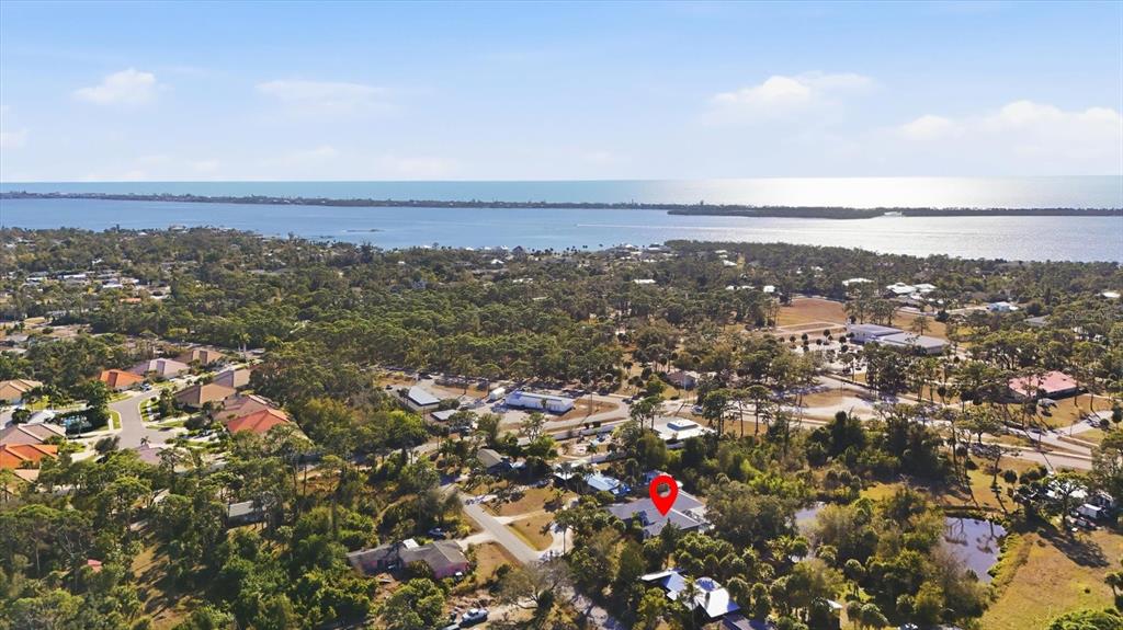 An aerial view shows a residential neighborhood with a red location pin on a house — 750 HARMONY LANE, ENGLEWOOD, FL
