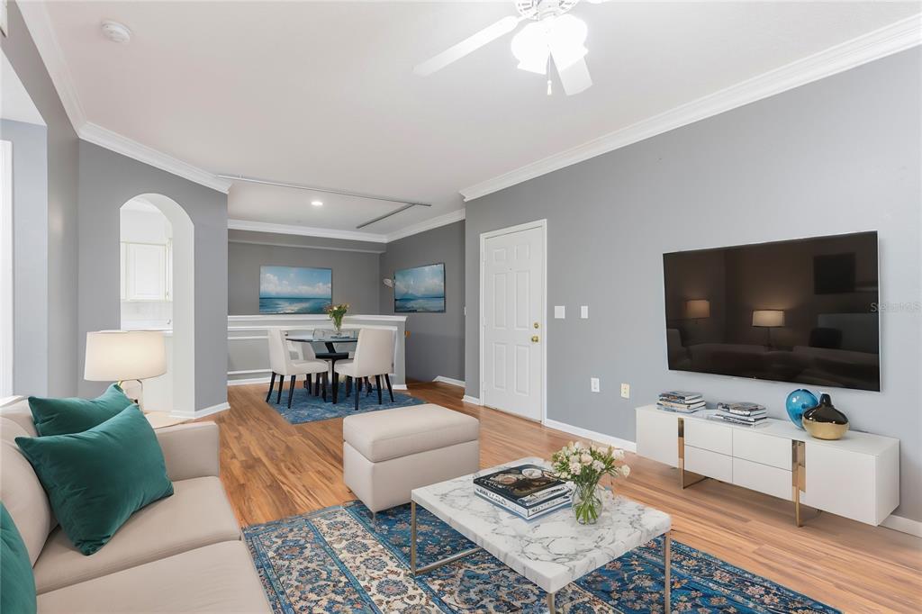 A living room and dining area feature gray walls, wood flooring, and blue area rugs — 3205 BAY CLUB CIRCLE UNIT 3205, TAMPA, FL
