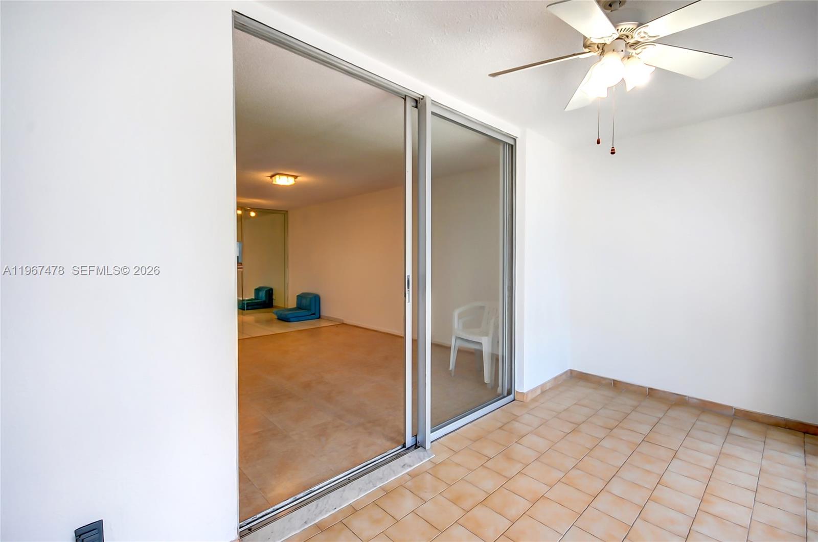 A tiled balcony features sliding glass doors leading into an interior room with a ceiling fan — 301 NE 14th Ave # 702, Hallandale Beach FL 33009, HALLANDALE BEACH, FL