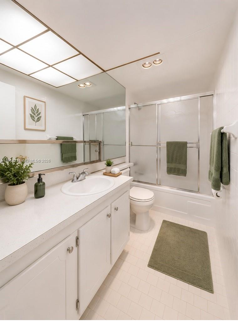 A bright bathroom features a white vanity, a large mirror, and a shower-tub combination — 301 NE 14th Ave # 702, Hallandale Beach FL 33009, HALLANDALE BEACH, FL