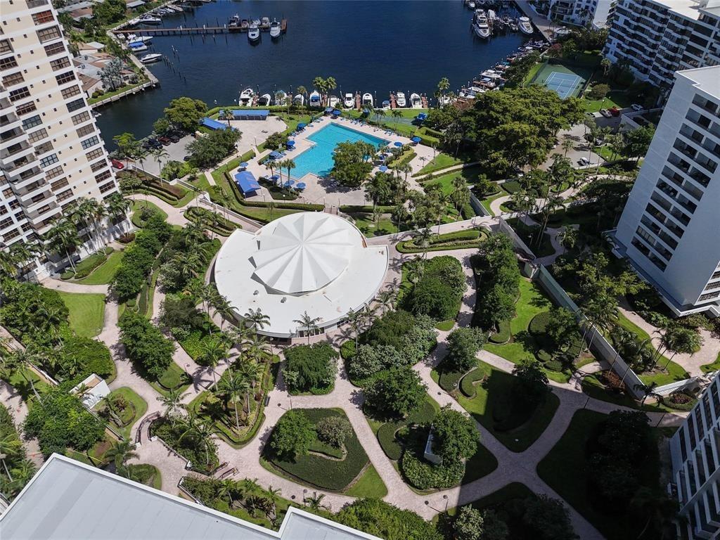 An aerial view shows a circular building, a swimming pool, and a marina with boats — 2500 Parkview Drive # 403, Hallandale Beach FL 33009, HALLANDALE BEACH, FL