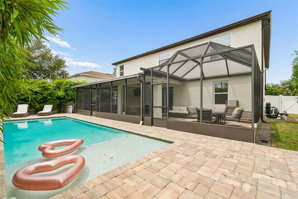 A two-story house with a screened-in patio and a swimming pool in the backyard — 23958 TERRACINA COURT, LAND O LAKES, FL