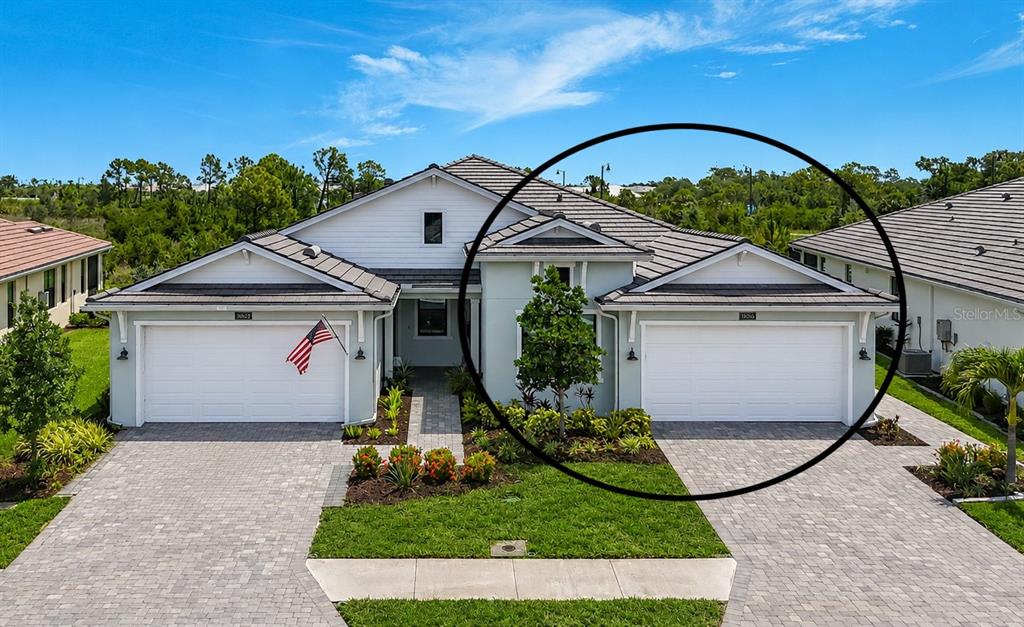 A front exterior view of a house featuring a circled single-car garage and driveway — 18604 DAYSPRING PLACE, VENICE, FL