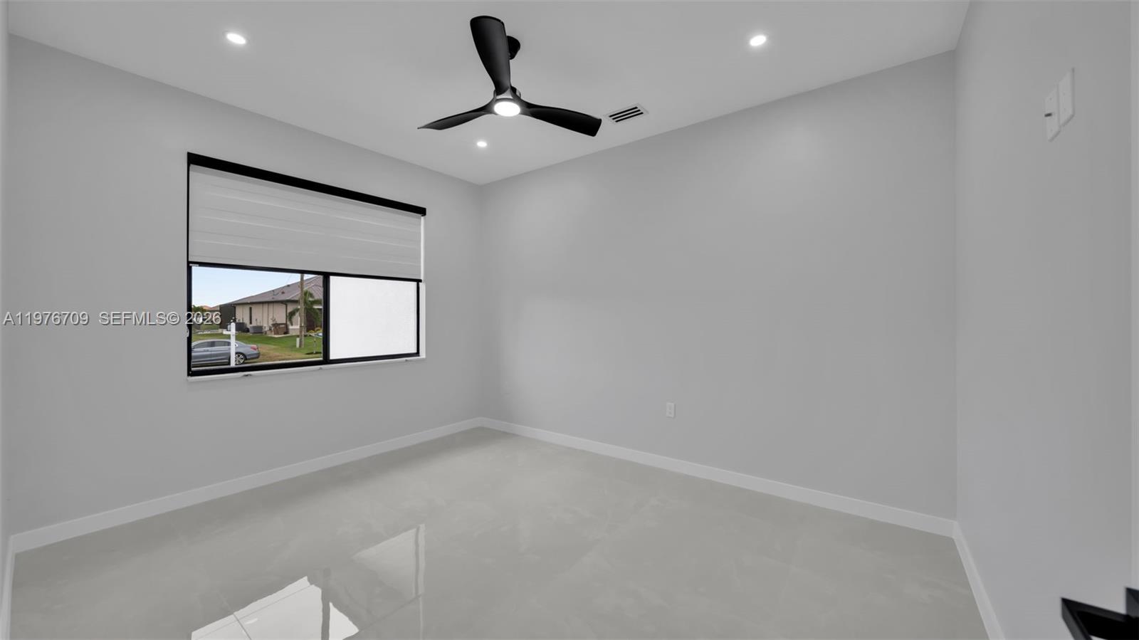 An empty bedroom features light gray walls, white tile flooring, and a black ceiling fan — 910 NW 36, Cape Coral FL 33993, CAPE CORAL, FL