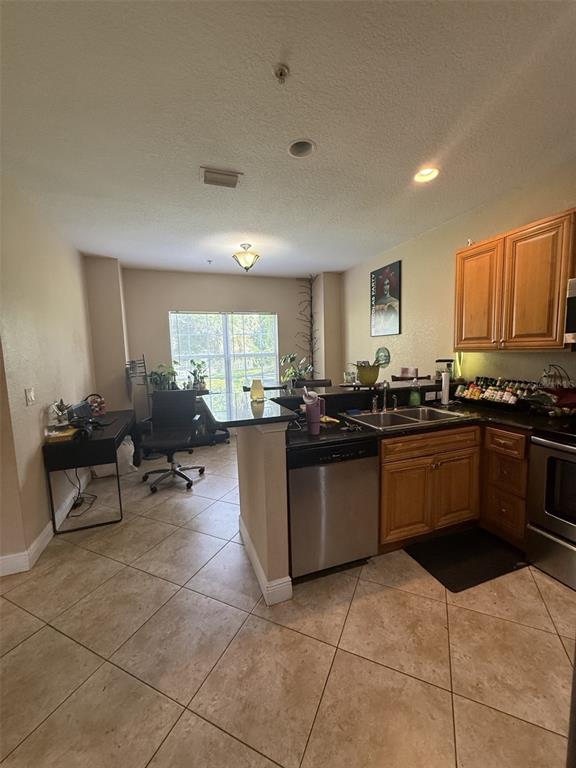 A kitchen with wood cabinets and stainless steel appliances opens to a dining area — 3721 S LAKE ORLANDO PARKWAY UNIT 3, ORLANDO, FL