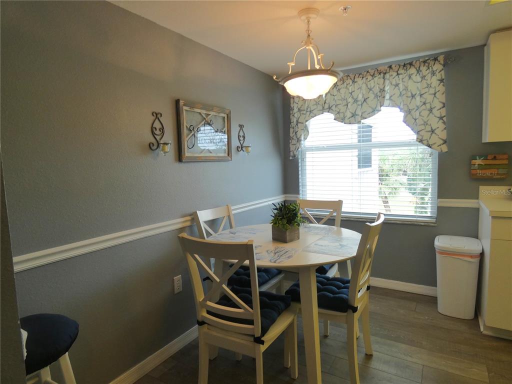 A dining area features a round white table, four chairs, and a window with valance — 9320 CLUBSIDE CIRCLE UNIT 2208, SARASOTA, FL