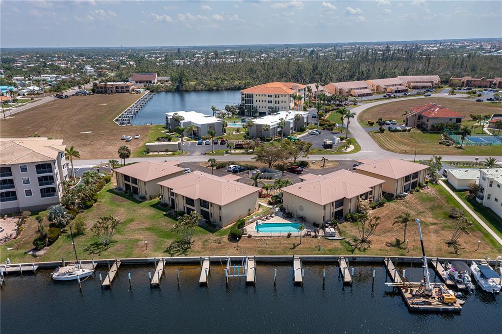 An aerial view of waterfront condominium buildings with boat docks and a swimming pool — 3221 WHITE IBIS COURT UNIT D2, PUNTA GORDA, FL