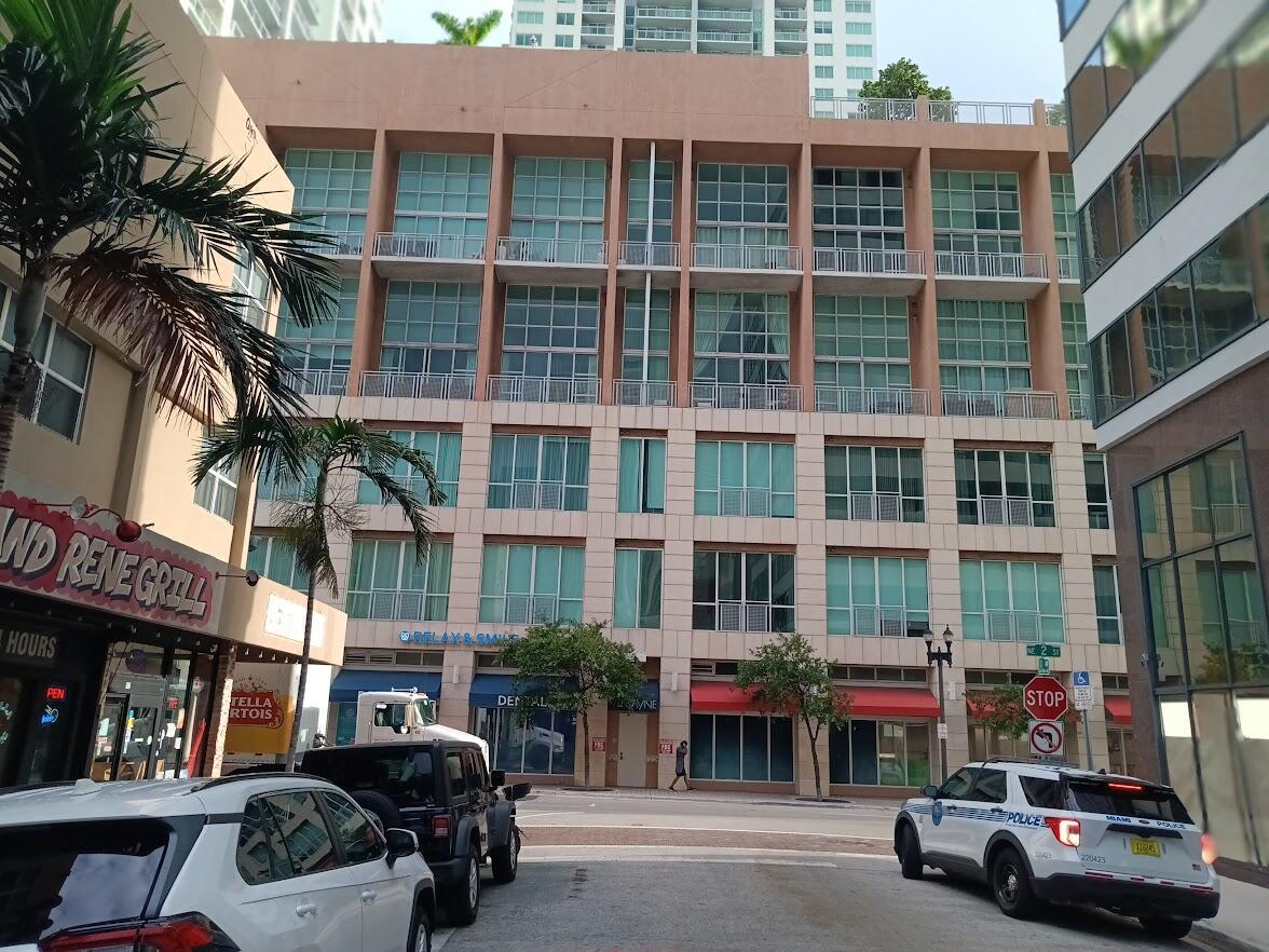 A multi-story building with a tan facade and large windows sits above street-level storefronts — 253 NE 2nd Street # 221, Miami FL 33132, MIAMI, FL