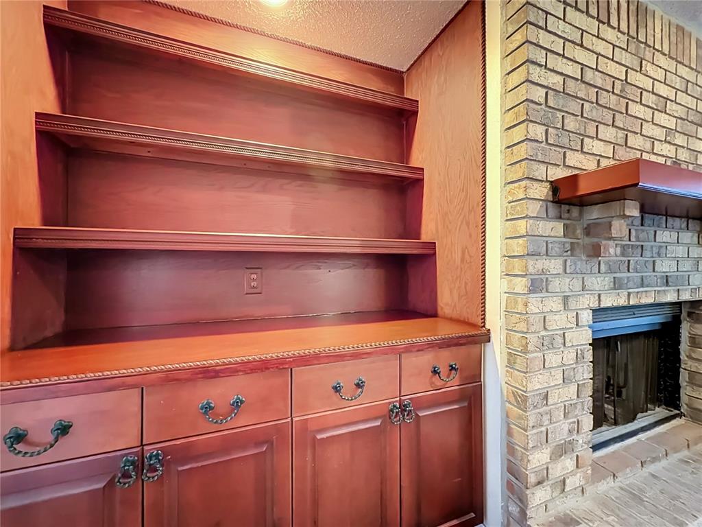 A built-in wooden shelving unit and cabinets stand next to a brick fireplace — 5427 SAGO PALM COURT, ORLANDO, FL