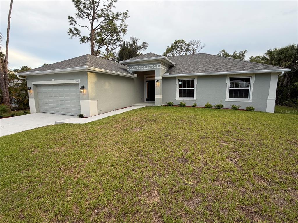 A single-story house with a gray stucco exterior, a two-car garage, and a front lawn — 20237 NAVAJO LANE, PORT CHARLOTTE, FL
