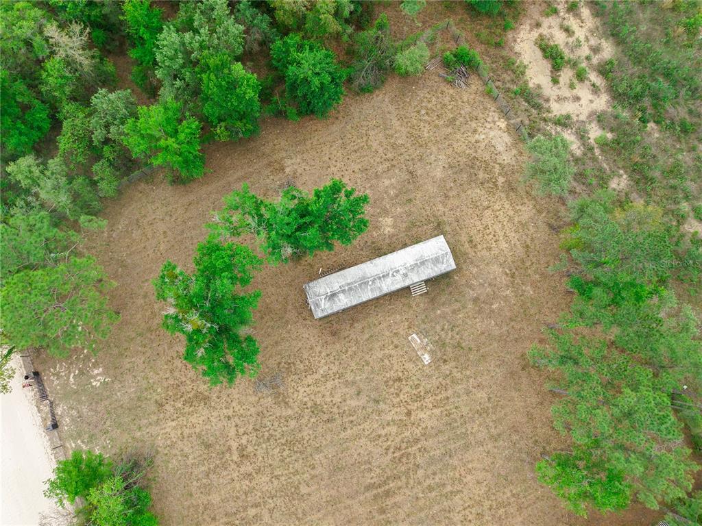 An aerial view shows a rectangular mobile home situated on a large, partially wooded lot — 1390 NE 130TH AVENUE, WILLISTON, FL