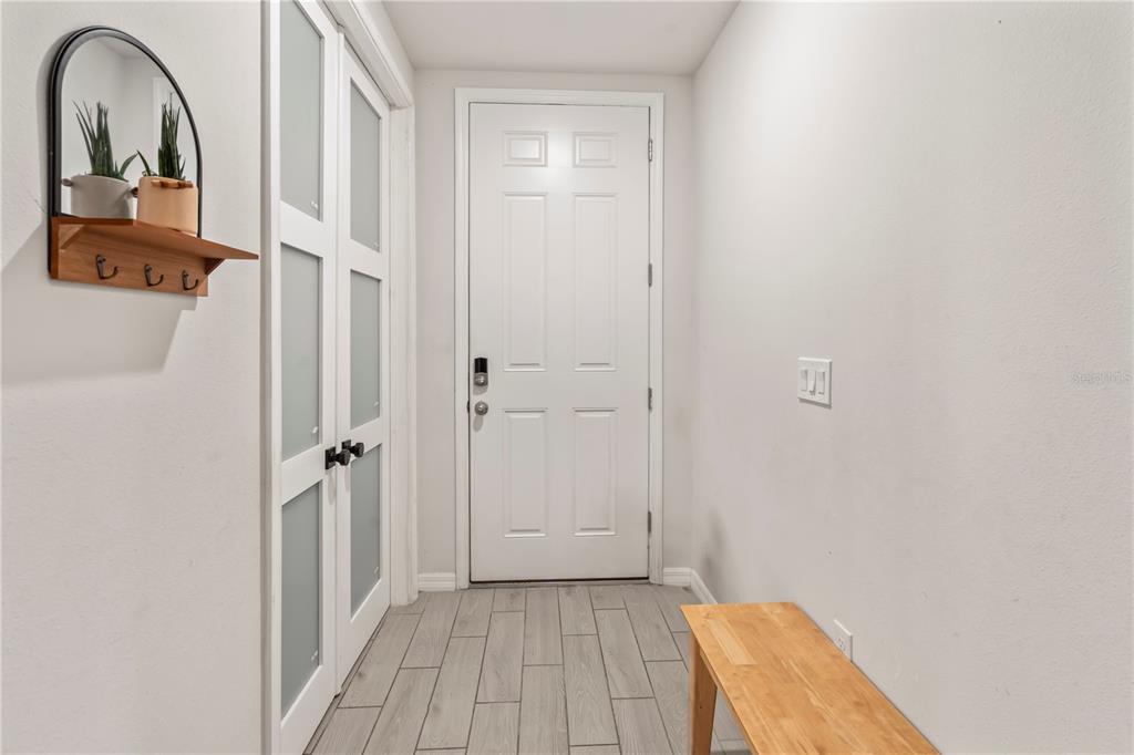 A view from a hallway looking into an open-concept kitchen and living area — 551 AMADORAS WAY, ST CLOUD, FL
