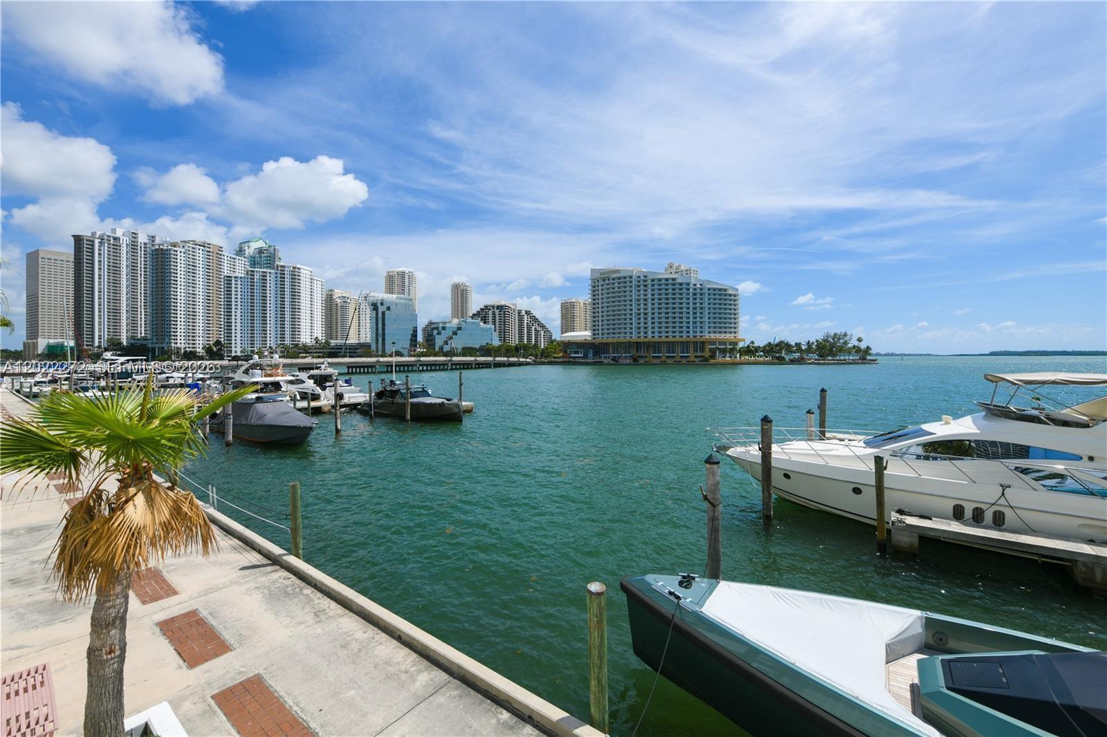 A view of a marina with several yachts docked in front of a city skyline — 999 Brickell Bay Dr # 209, Miami FL 33131, MIAMI, FL