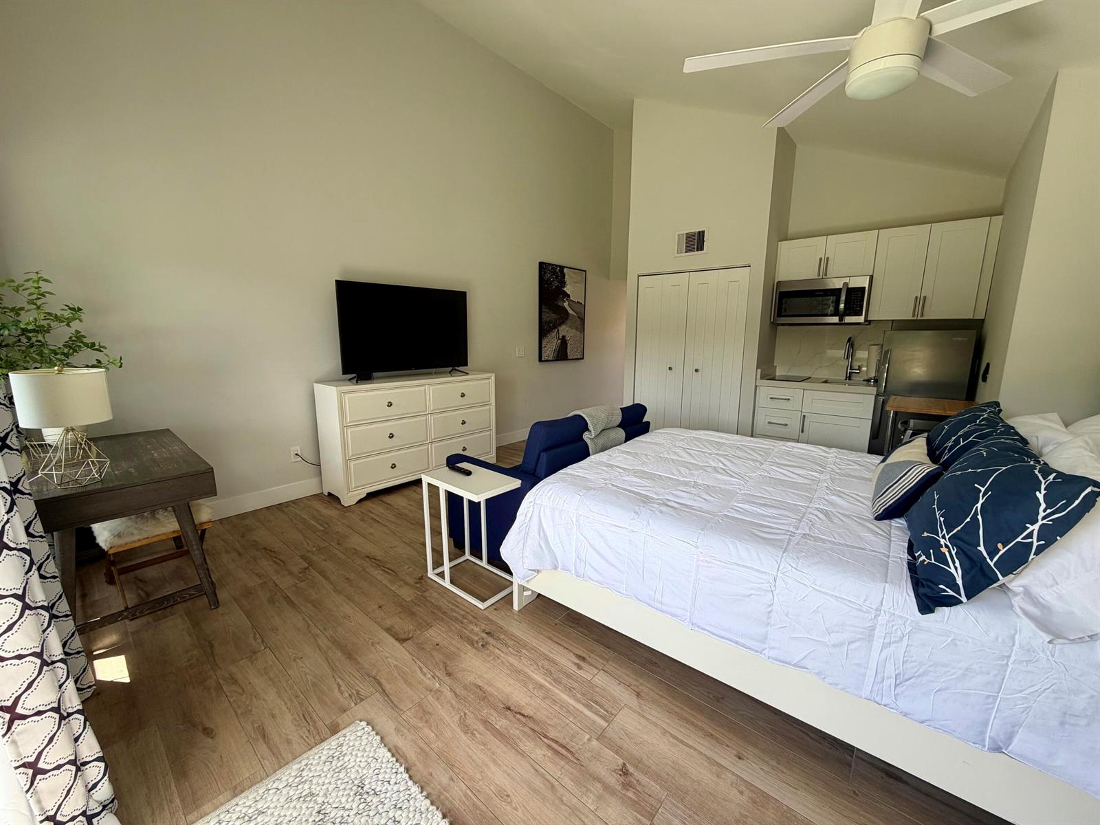 A studio apartment features a bed, a small kitchen, a dresser, and a desk — 11863 Wimbledon Circle # 536, Wellington FL 33414, WELLINGTON, FL