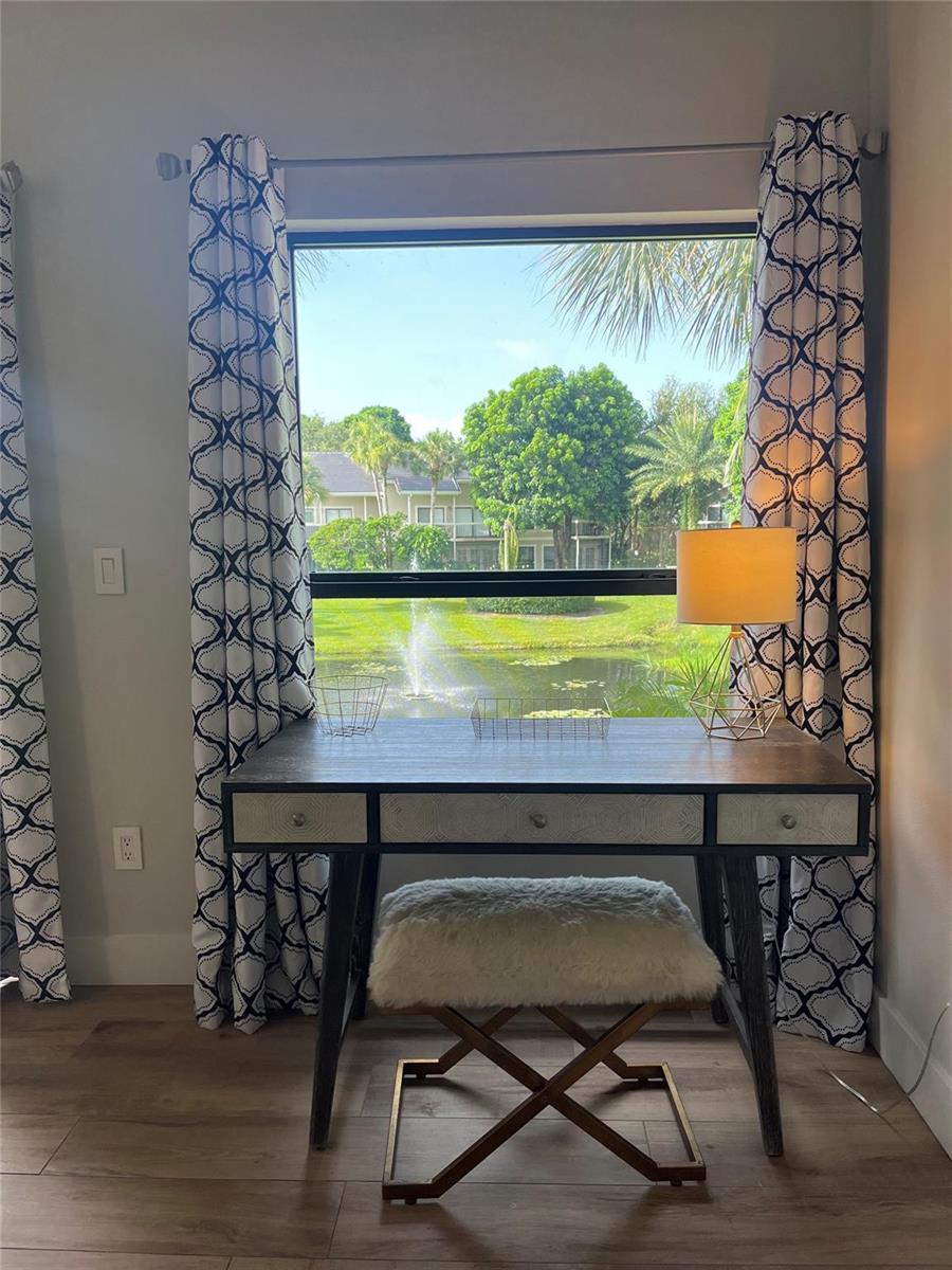A desk with a fur stool sits in front of a window overlooking a pond — 11863 Wimbledon Circle # 536, Wellington FL 33414, WELLINGTON, FL