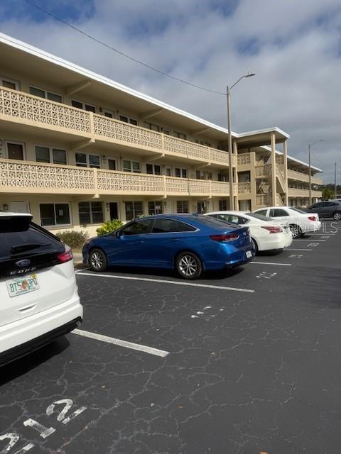 A multi-story apartment building with a decorative concrete facade overlooks a parking lot — 1051 79TH AVENUE N UNIT 212, ST PETERSBURG, FL