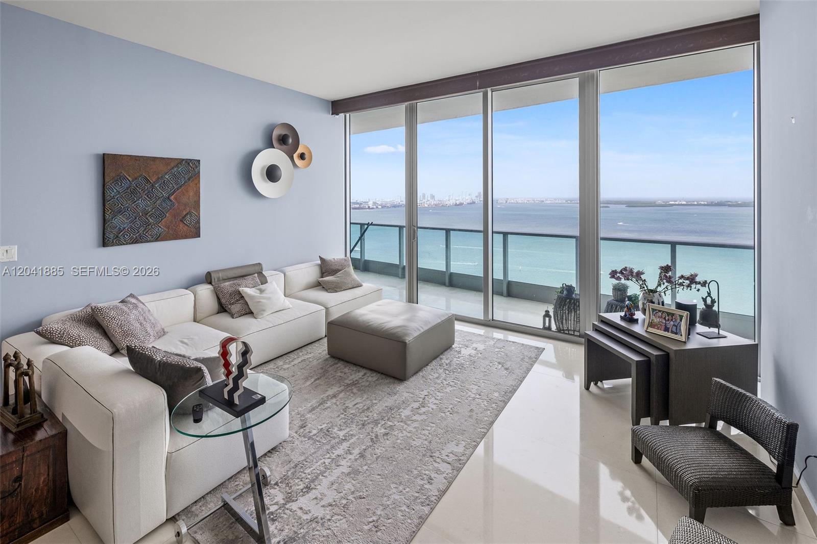 A modern living room features a white sectional sofa, a large rug, and floor-to-ceiling windows — 1331 Brickell Bay Dr # 2909, Miami FL 33131, MIAMI, FL