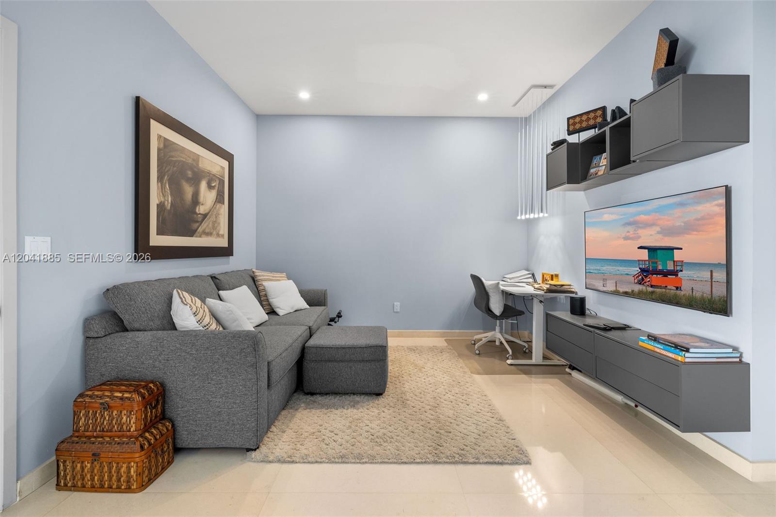 A living room features a gray sofa, a wall-mounted television, and a small desk area — 1331 Brickell Bay Dr # 2909, Miami FL 33131, MIAMI, FL