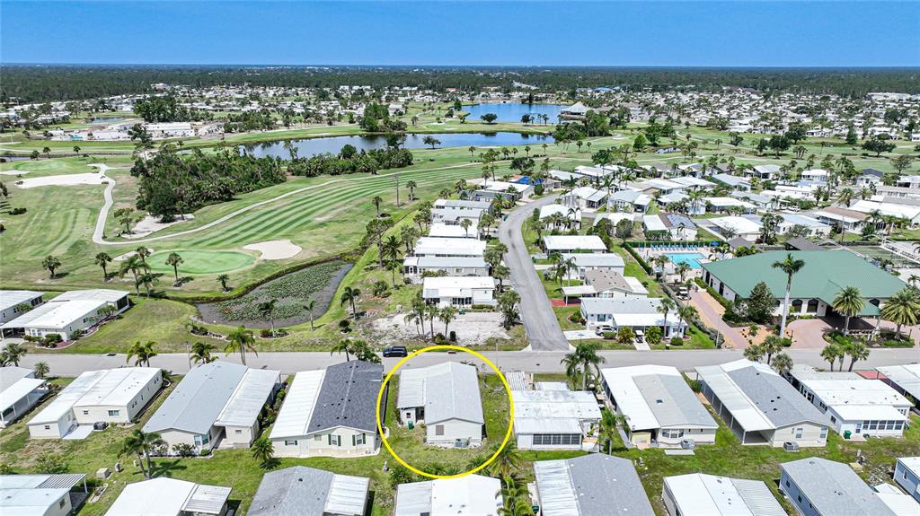 An aerial view shows a single-story house with a light-colored roof in a residential neighborhood — 2100 KINGS HIGHWAY UNIT 517, PORT CHARLOTTE, FL
