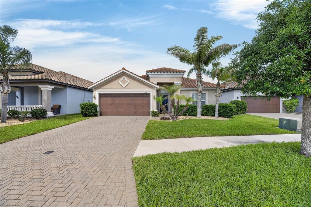 A single-story house with a brown garage, a paved driveway, and palm trees in front — 13168 GREEN VIOLET DRIVE, RIVERVIEW, FL