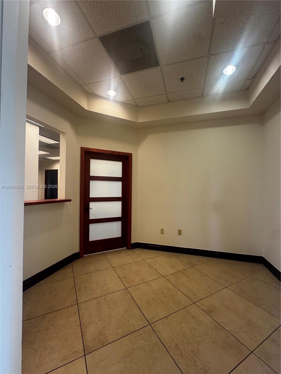 A small office space features a wood-framed door with frosted glass panels and tile flooring — 1655 N Commerce Pkwy # 301, Weston FL 33326, WESTON, FL