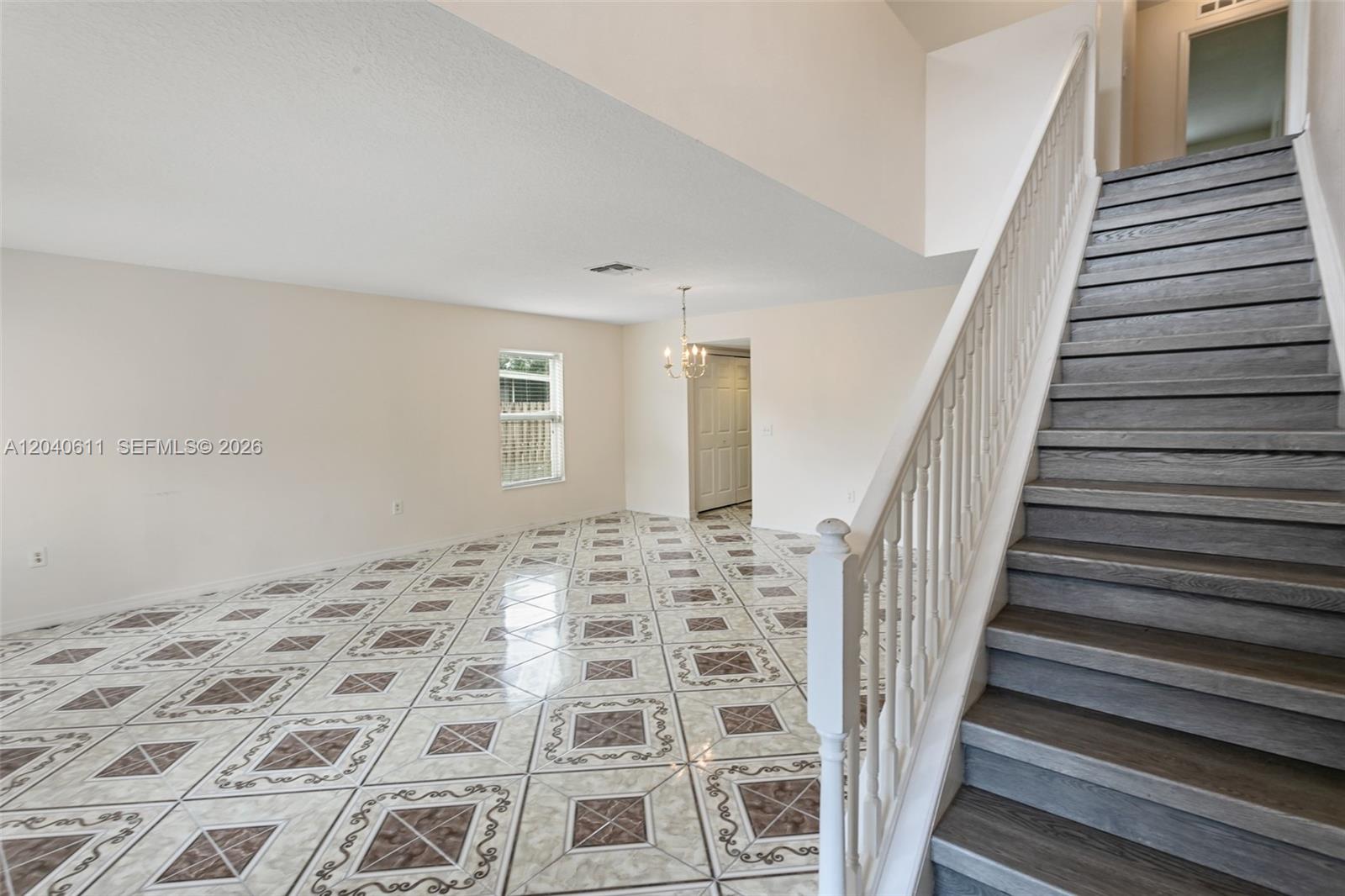 A room with patterned tile flooring and a staircase with gray treads and white railings — 12096 Prospect Creek Dr # 0, Jacksonville FL 32218, JACKSONVILLE, FL