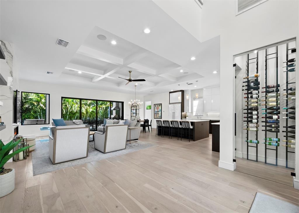 A modern open-concept living area features a coffered ceiling, light wood floors, and a wine cellar — 1717 ALTA VISTA STREET, SARASOTA, FL