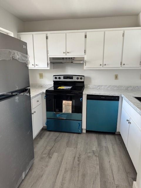 A kitchen features white cabinets, stainless steel appliances, and light wood-look flooring — 13404 SW 62nd St # 101L, Miami FL 33183, MIAMI, FL