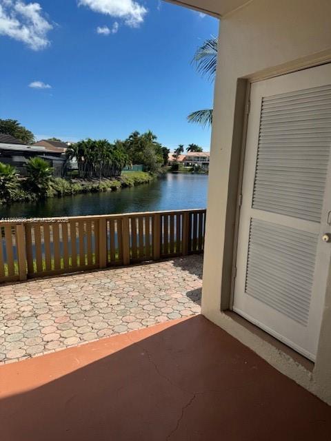 A patio with a paved floor overlooks a canal and a wooden fence — 13404 SW 62nd St # 101L, Miami FL 33183, MIAMI, FL