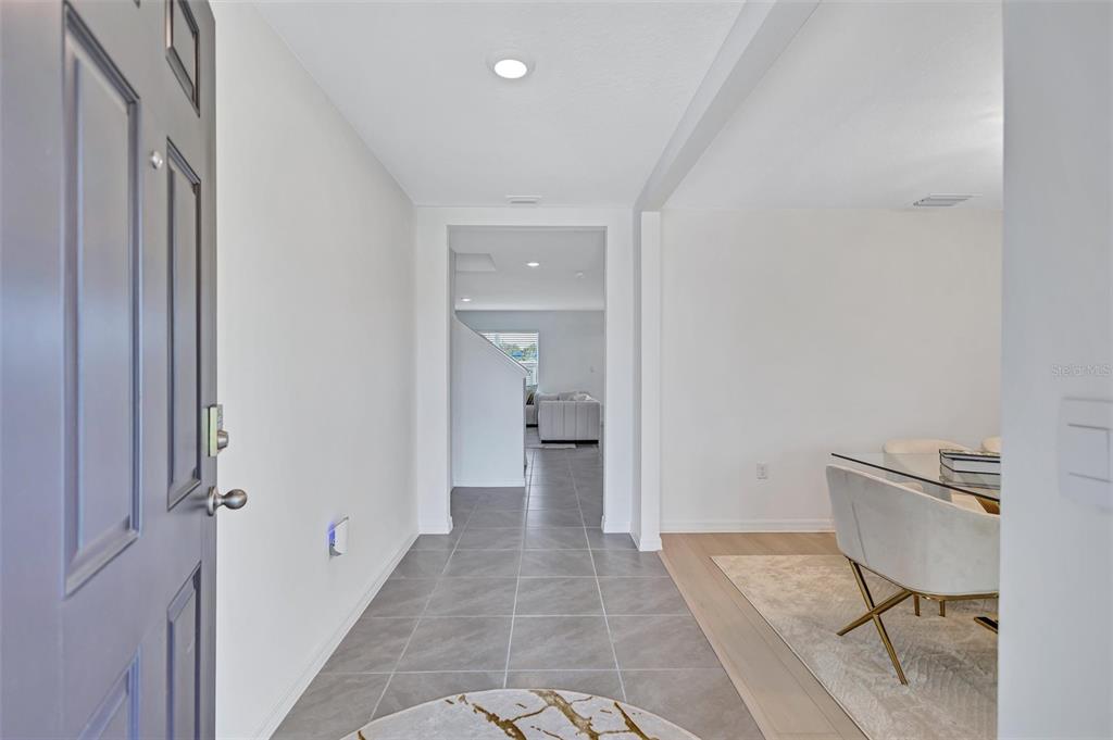 A view from an open front door into a tiled entryway leading to a living area — 7601 ROSEWOOD GARDEN LOOP, TAMPA, FL