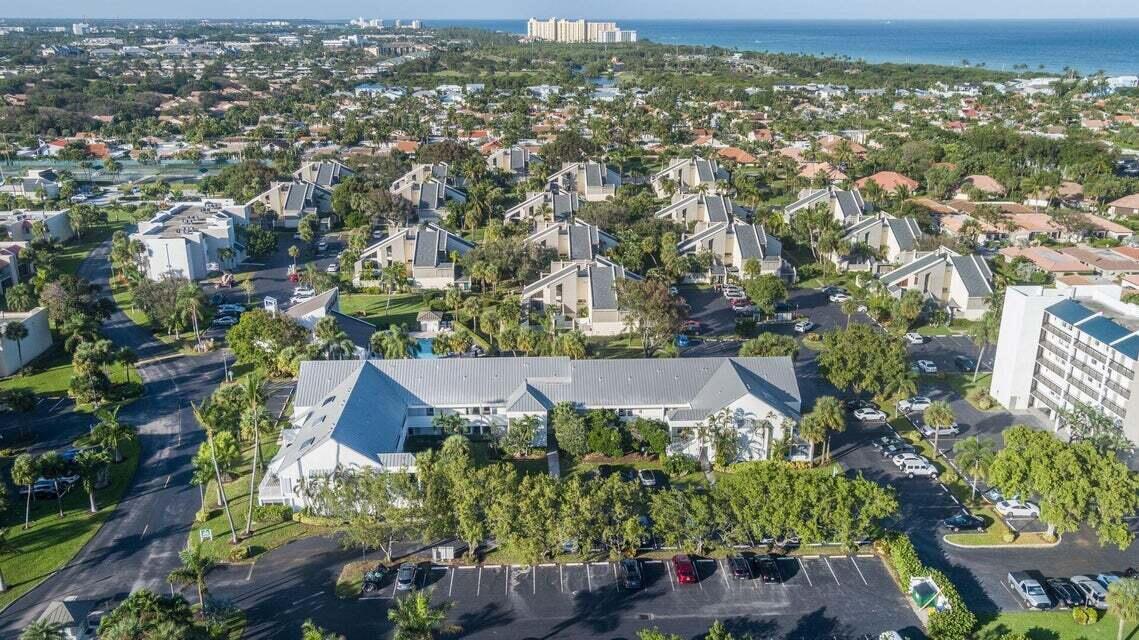 An aerial view shows a multi-unit residential complex with gray roofs surrounded by lush landscaping — 1605 S Us Highway 1 # 214, Jupiter FL 33477, JUPITER, FL
