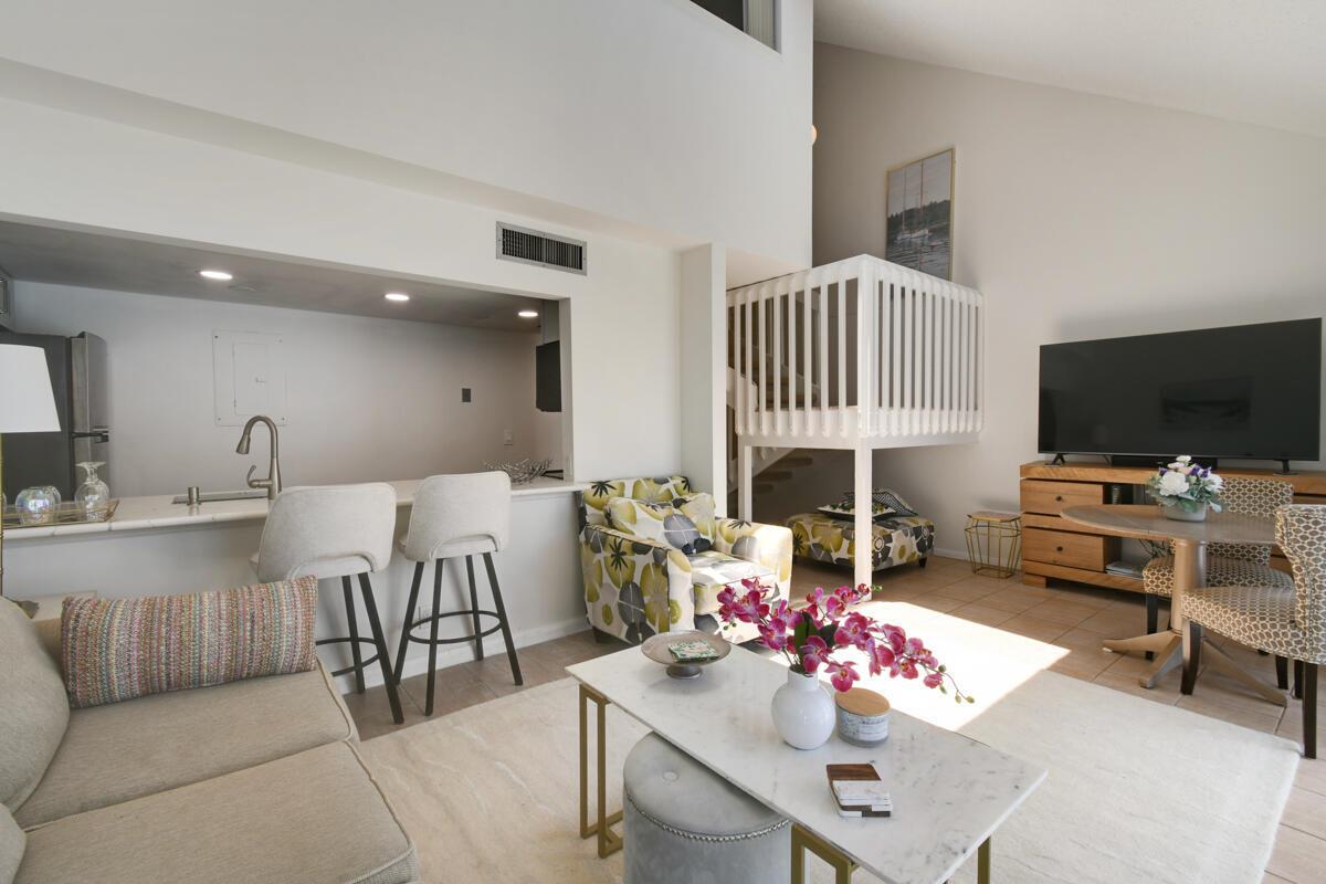 A living room with a kitchen pass-through, a loft area, and a dining space — 1605 S Us Highway 1 # 214, Jupiter FL 33477, JUPITER, FL