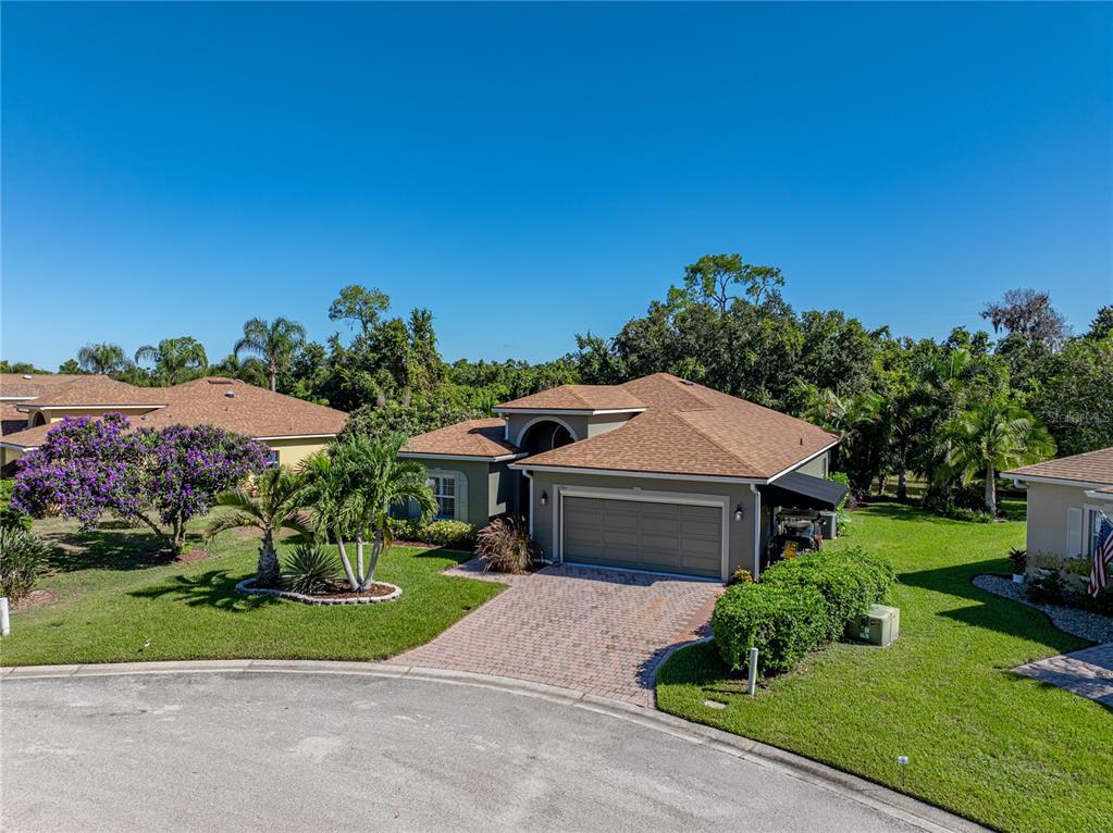 A single-story house with a tan exterior, brown roof, and a paved driveway — 4184 ABERDEEN LANE, LAKE WALES, FL