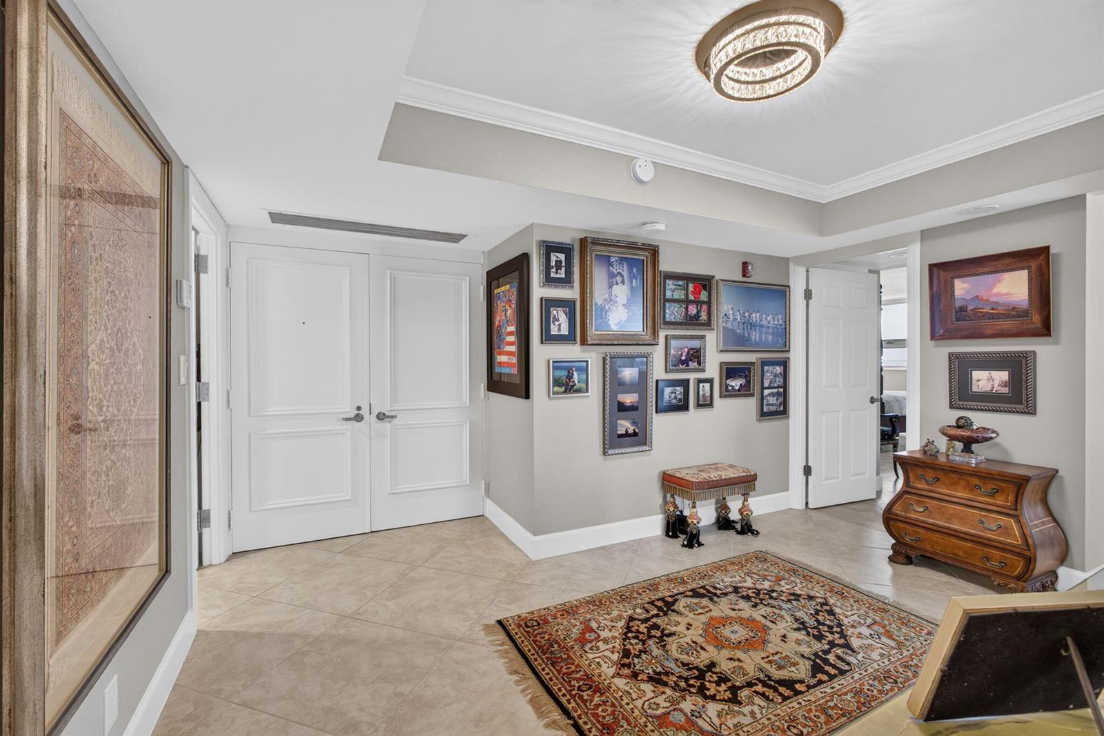 An entryway features tile flooring, a patterned area rug, a gallery wall, and wooden furniture — 5280 N Ocean Drive # 3a, Singer Island FL 33404, SINGER ISLAND, FL