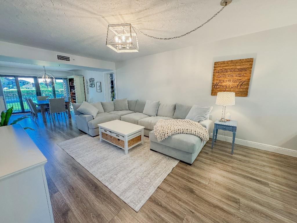 A living room features a light gray sectional sofa, a white coffee table, and wood flooring — 901 Seafarer Circle # 101, Jupiter FL 33477, JUPITER, FL