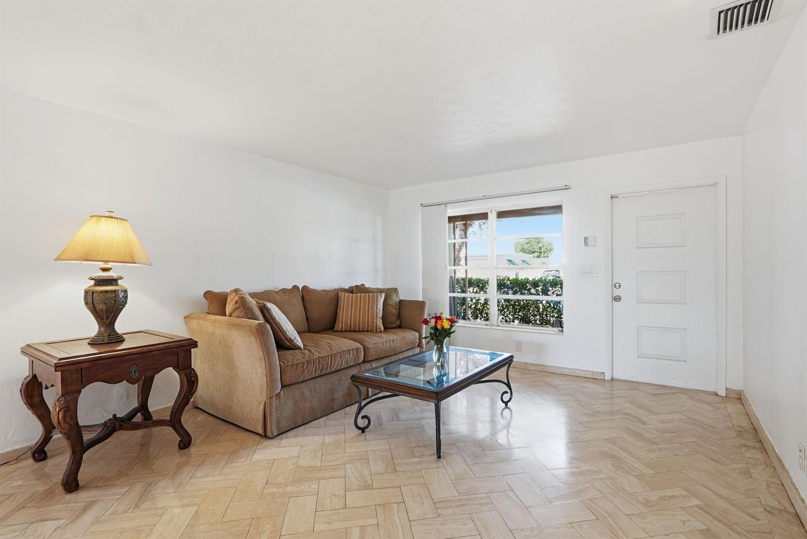 A living room features a brown sofa, a glass coffee table, and light tile flooring — 218 SE 3rd Terrace, Dania Beach FL 33004, DANIA BEACH, FL