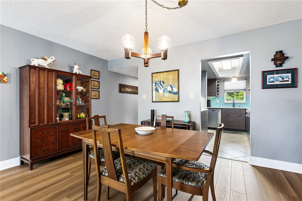 A dining room with a wooden table, chairs, a hutch, and a view into the kitchen — 601 N MCDONALD STREET UNIT 310, MOUNT DORA, FL