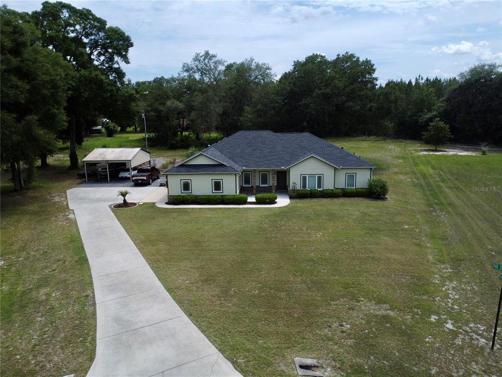 An aerial view shows a single-story house with a driveway and a detached carport — 18450 NE 61ST LANE, WILLISTON, FL