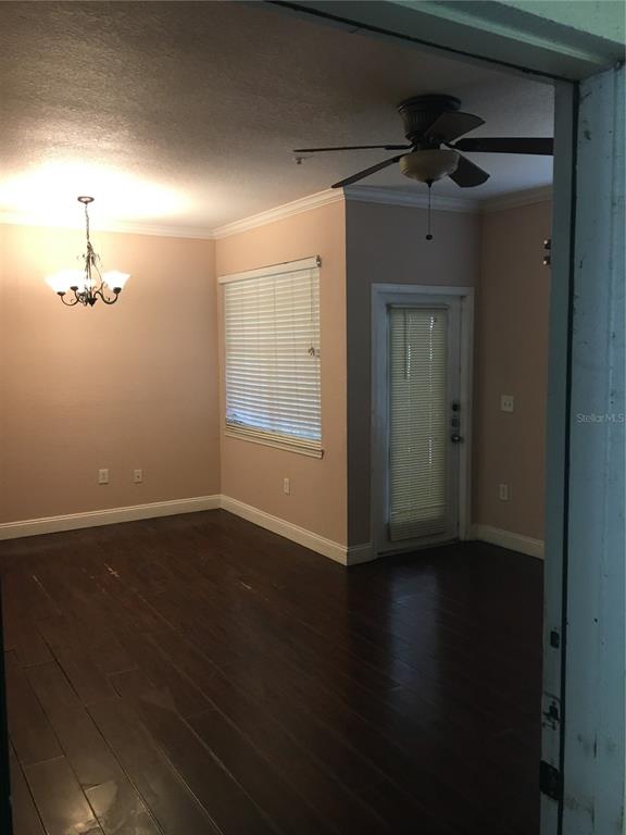 A room with dark wood flooring, a ceiling fan, a chandelier, and a glass-paneled door — 2572 ROBERT TRENT JONES DRIVE UNIT 1215, ORLANDO, FL