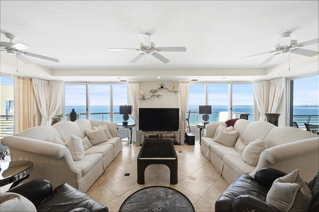 A living room with two white sofas, a central coffee table, and ocean views — 1350 GULF BOULEVARD UNIT 901, CLEARWATER BEACH, FL