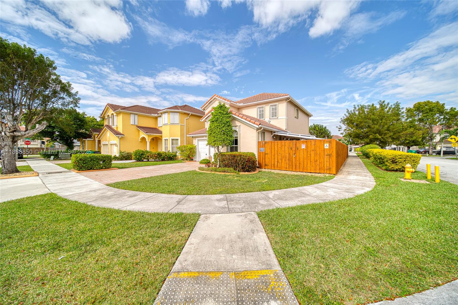 A two-story beige house with a wooden fence sits on a corner lot — 16403 SW 79th Ln # 16403, Miami FL 33193, MIAMI, FL