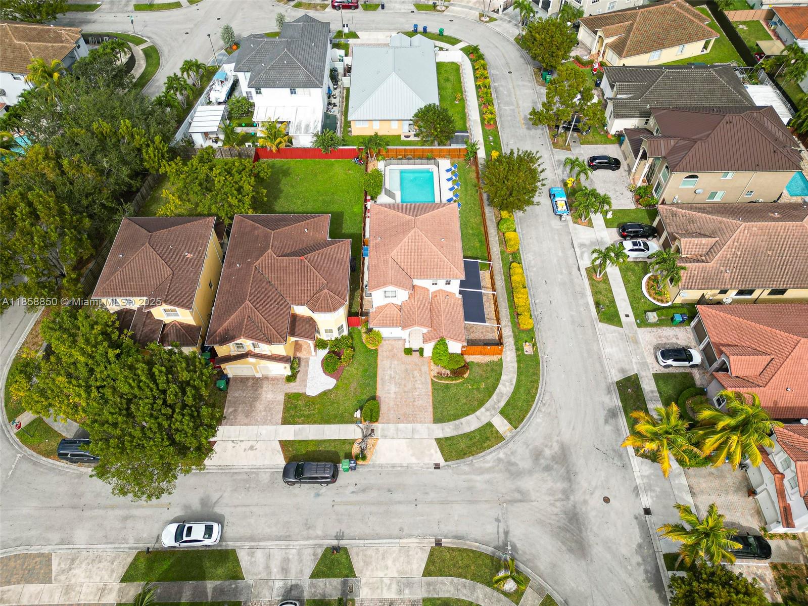 An aerial view shows suburban houses with tiled roofs, swimming pools, and paved driveways — 16403 SW 79th Ln # 16403, Miami FL 33193, MIAMI, FL