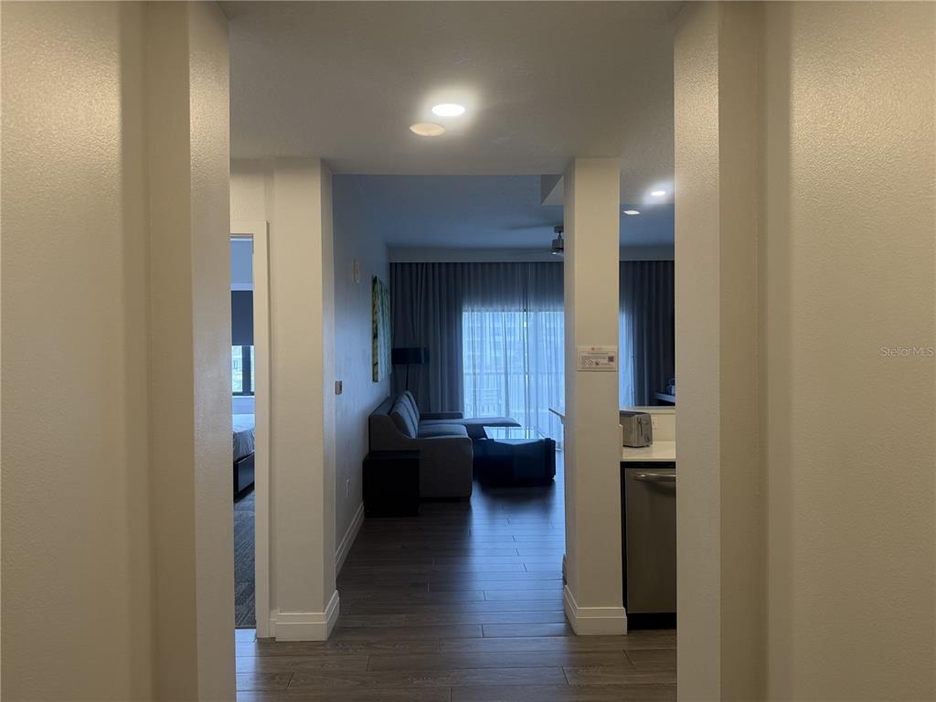 A view from a hallway looking into a living room with a sofa and kitchen — 14501 GROVE RESORT AVENUE UNIT 2223, WINTER GARDEN, FL