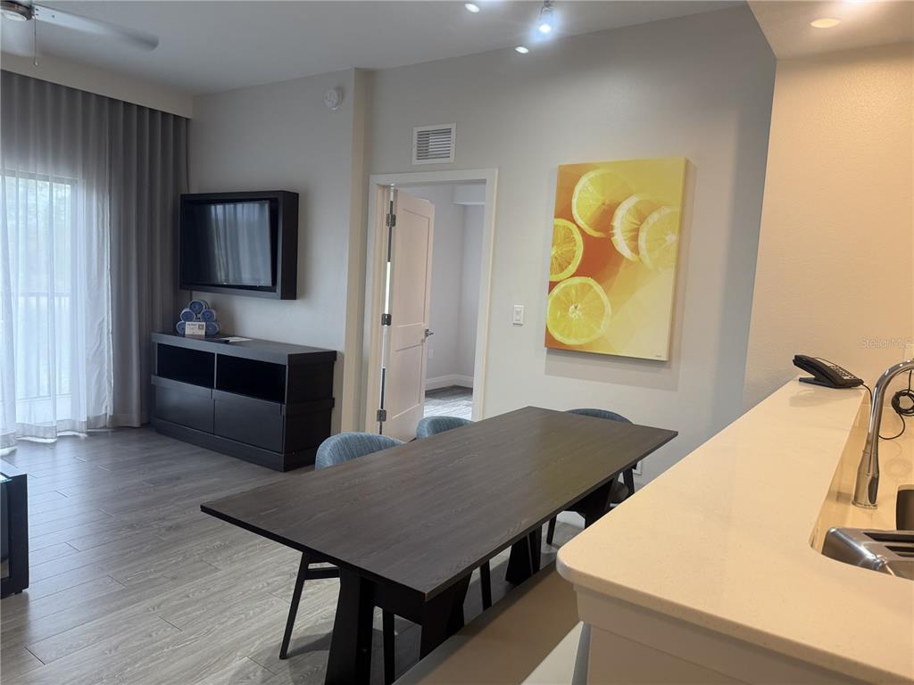 A dining area with a dark wood table sits adjacent to a kitchen counter — 14501 GROVE RESORT AVENUE UNIT 2223, WINTER GARDEN, FL