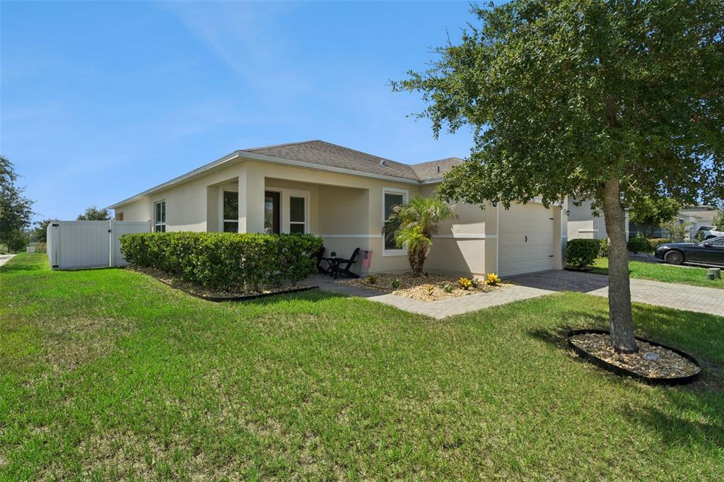 A single-story house with a beige exterior, a paved driveway, and a front yard tree — 253 SPARROW HAWK DRIVE, GROVELAND, FL