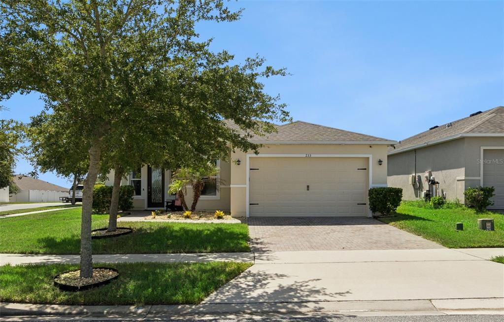 A single-story house with a beige exterior, a two-car garage, and a paved driveway — 253 SPARROW HAWK DRIVE, GROVELAND, FL