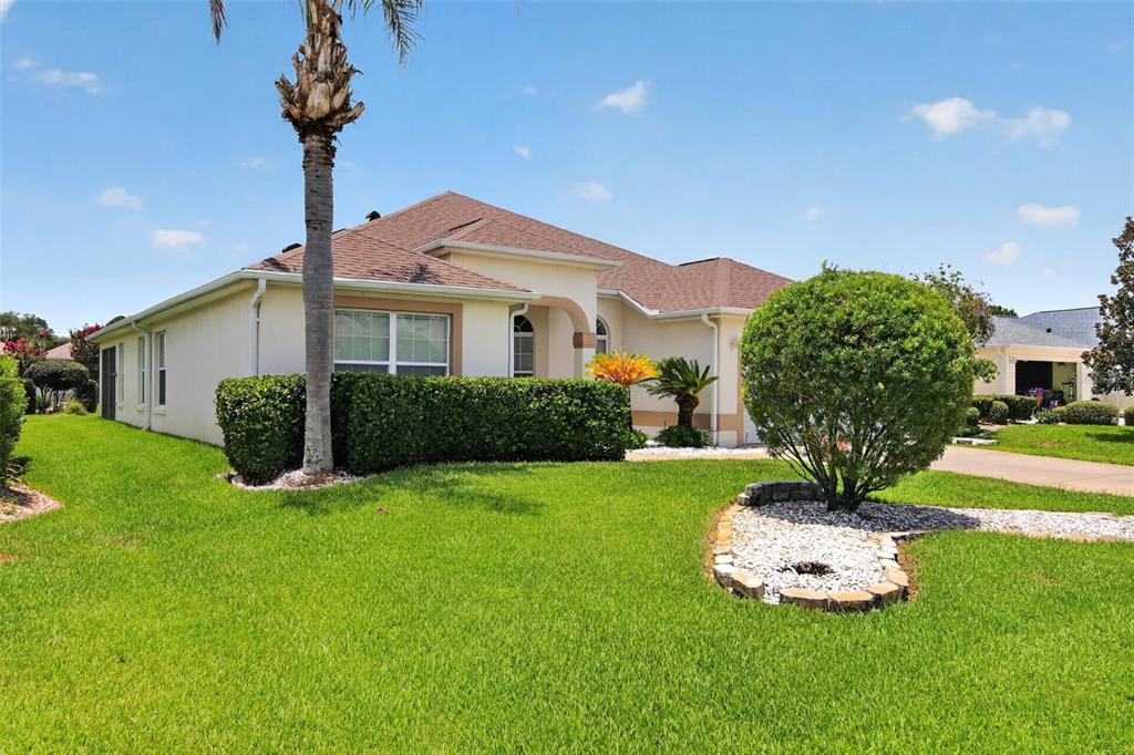A single-story house with a tan exterior, a palm tree, and a manicured lawn — 17336 SE 80TH TURNBULL COURT, THE VILLAGES, FL