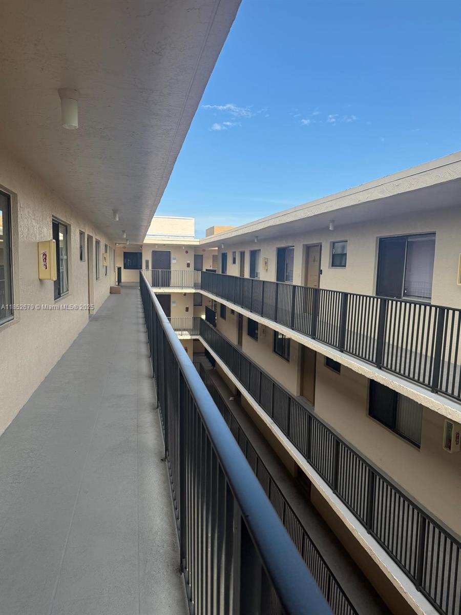 An exterior view of an apartment building walkway with metal railings and multiple levels — 8040 Hampton Blvd # 512, North Lauderdale FL 33068, NORTH LAUDERDALE, FL